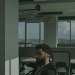 a man in black jacket sitting on a chair